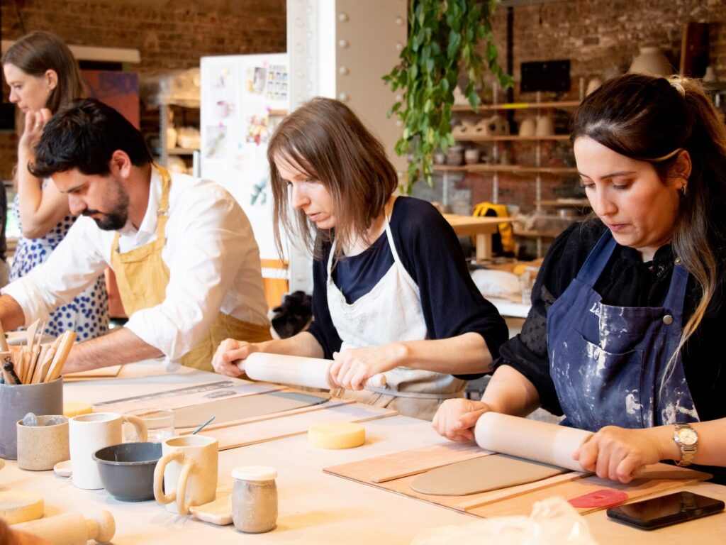 Participants shaping clay during a group ceramics workshop