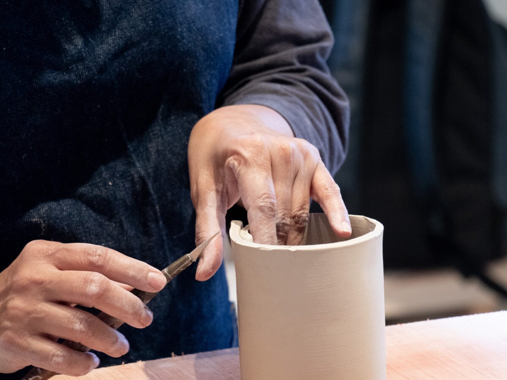 zoom on the hands of someone modelling a clay creation during a ceramics workshop