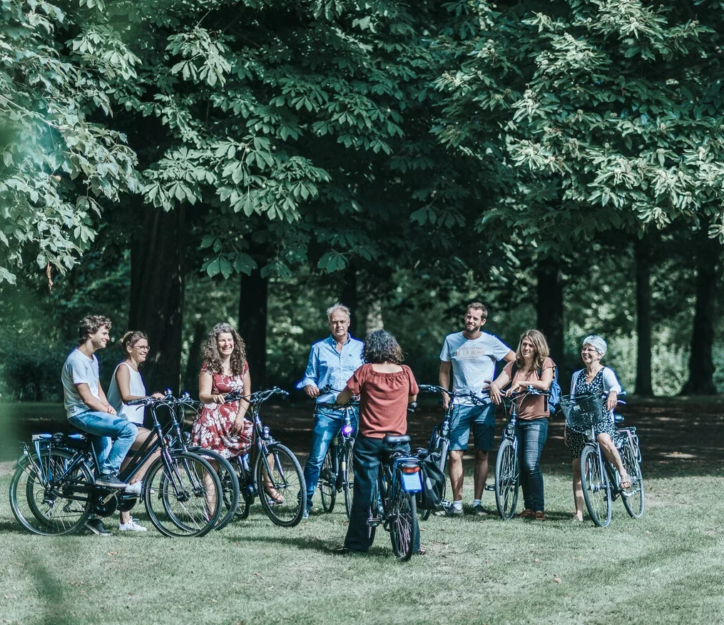 A group of people taking a break in the heart of nature during a team-building bike ride.