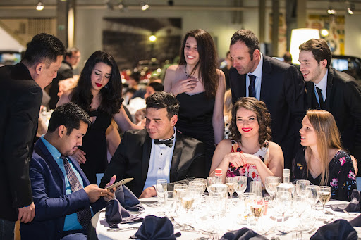 Team around a table taking part in a digital animation during a team building dinner show