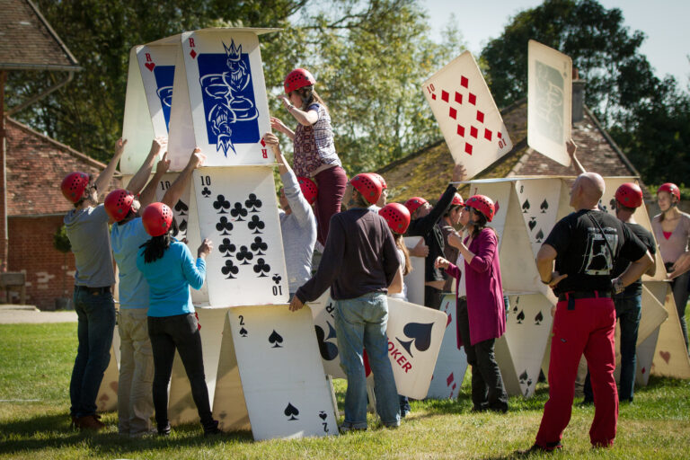 group of people building a giant house of cards