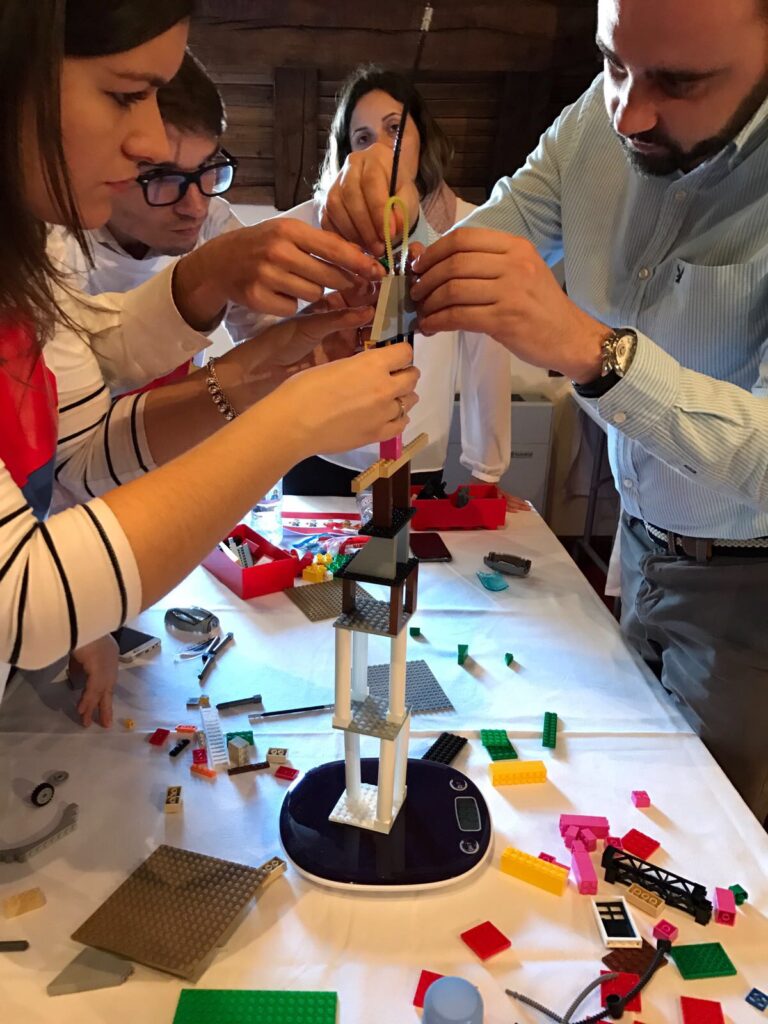 people building a Lego tower during a team building Lego challenge