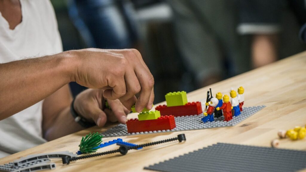 someone creating something out of Lego in a Lego Challenge team building activity
