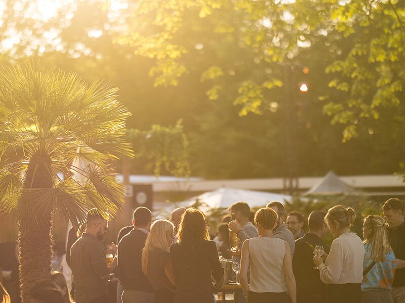 ambiance animée où la foule est rassemblée sous un couché de soleil à La Terrasse O2