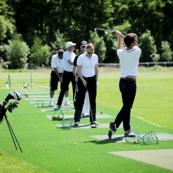 group of people in the middle of a golf practice during an initiation team building session