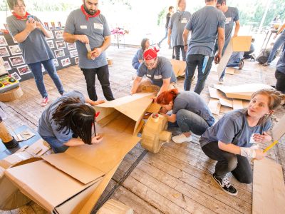 team working together to build a cardboard racing car during a team building event