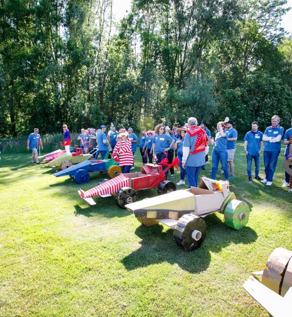 Teams ready to start a cardboard car race during an outdoor team building event