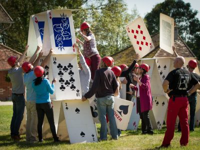 group of people building a giant house of cards